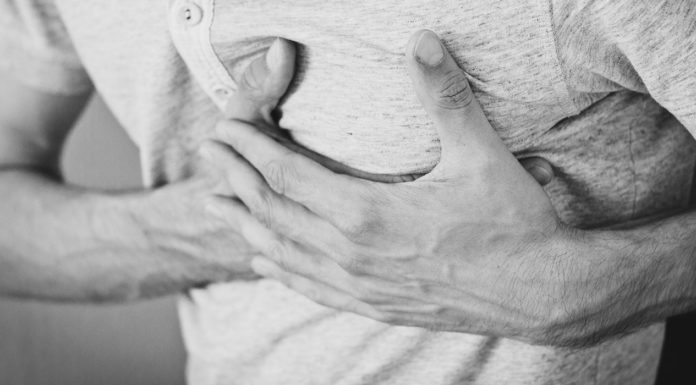 Angina: Causes, Symptoms & Prevention A picture of a man holding his left chest region
