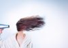 Smelly Hair and Scalp: Prevention and Cure A woman holding a hair drier, and wearing a bathroom robe