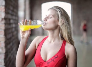 Home Remedies For Urinary Tract Infection a woman drinking some juice