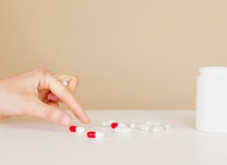 12 Niacin (Vitamin B3) Rich Foods picking up a tablet